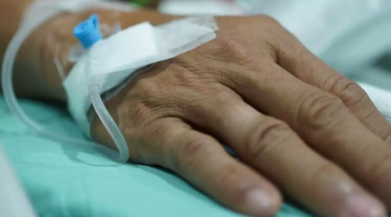 Mão de um paciente idoso com entrada de soro