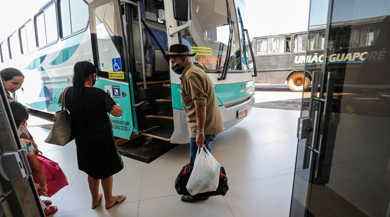 Idosos entrando em ônibus em rodoviária